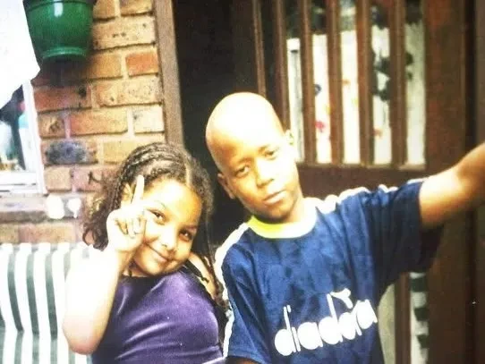 An old picture depicting two young children, roughly the age of elementary school. 