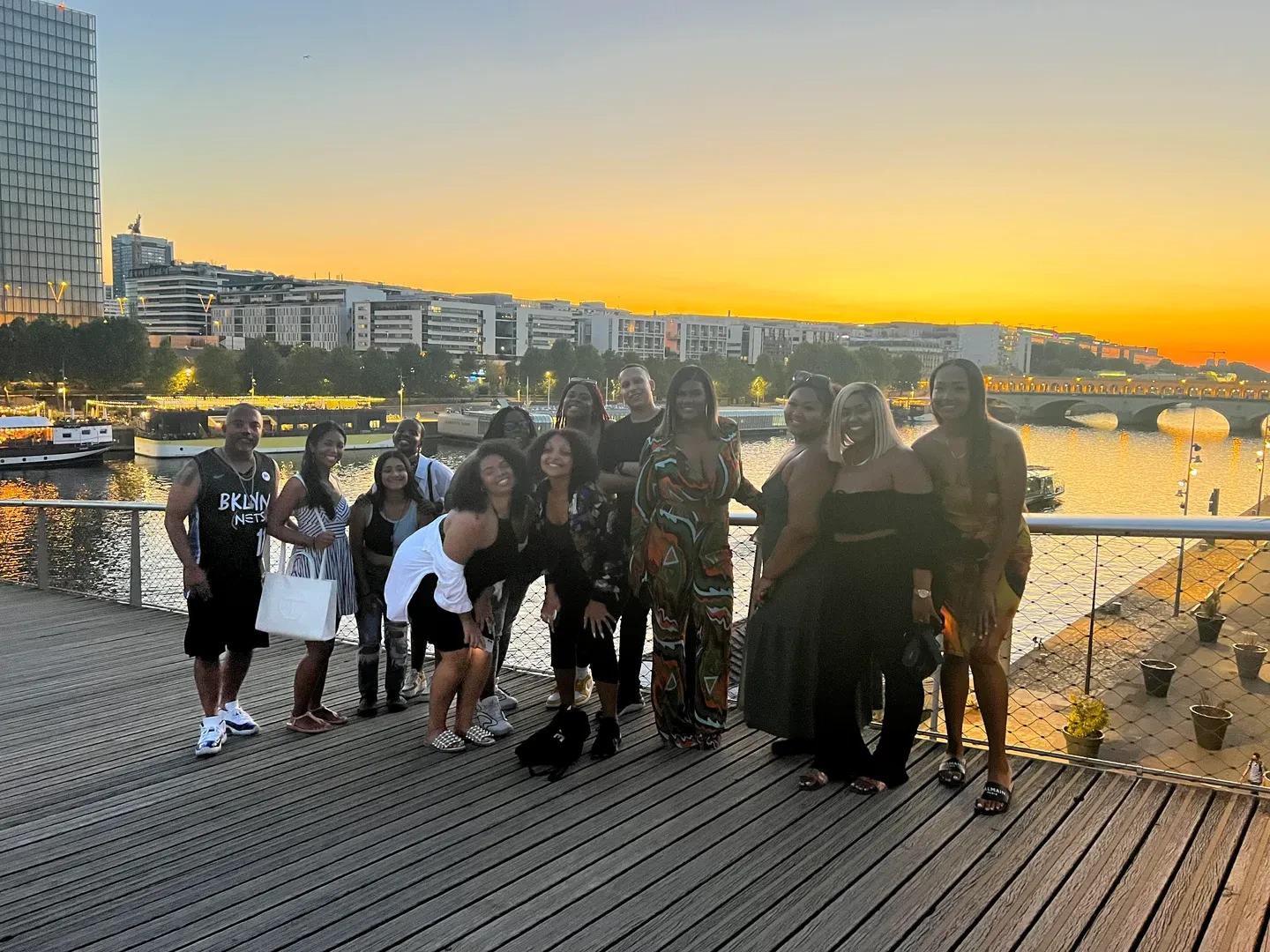 A large group of people standing on a bridge, facing the camera with a smile.